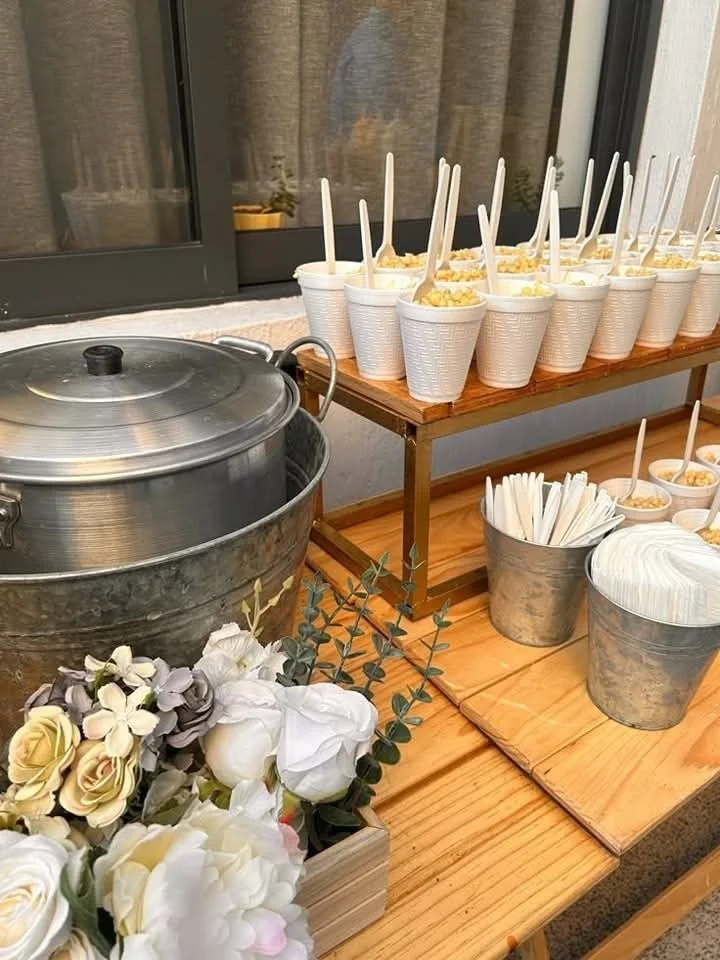 Montaje de esquites con vasos, flores y olla de servicio